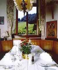 a table with glasses and flowers on it with a window at Hotel Restaurant Ochsenwirtshof in Bad Rippoldsau-Schapbach