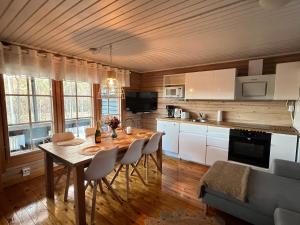 a kitchen with a table and chairs in a room at Villa Safari in Perniö