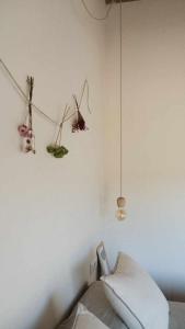 1 dormitorio con una pared blanca con plantas colgantes en Casa Diana A, en Girona
