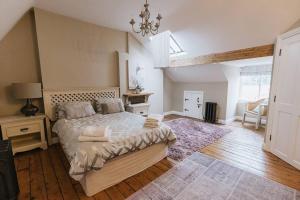 a bedroom with a large bed and a chandelier at HIGH SAINT COTTAGE - Stunning 3 Bed Accommodation located in Ripon, North Yorkshire in Ripon