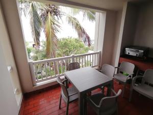 a balcony with a table and chairs and a window at 125 Laguna La Crete, Uvongo in Margate