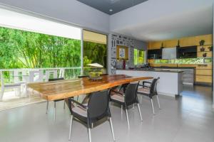 Il comprend une cuisine et une salle à manger avec une table et des chaises en bois. dans l'établissement CASA LUZ Hospedaje, Pereira , Cerritos, à Pereira