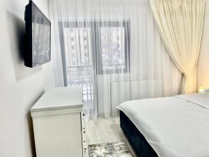 1 dormitorio con 1 cama, TV y ventana en TAJ en Ipoteşti