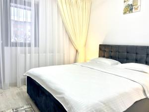 een slaapkamer met een groot bed en een raam bij TAJ in Ipoteşti +24 foto's