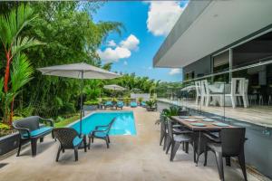 an outdoor patio with a table and chairs and a swimming pool at CASA LUZ Hospedaje, Pereira , Cerritos in Pereira