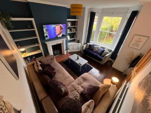 a living room with a couch and a flat screen tv at Stylish 4 bed house with parking in central Norwich in Norwich