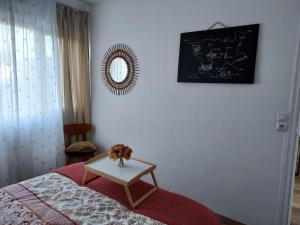 a bedroom with a bed and a table with flowers on it at Au Nid d'or : Appartement Tout confort Hyper Centre Béthune in Béthune