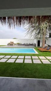 a swimming pool in the middle of a yard at Two Palm - Villa in Ras al Khaimah +4 photos