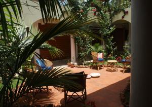 a courtyard with chairs and a table and a plant at Ashiyana Cliff and Beach Resort in Varkala