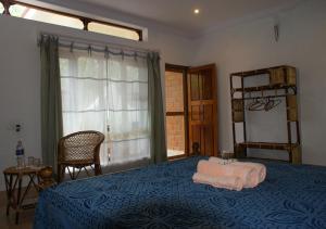 a bedroom with a blue bed with two towels on it at Ashiyana Cliff and Beach Resort in Varkala
