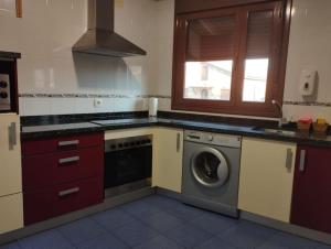 a kitchen with a washing machine and a window at Precioso piso con ducha hidromasaje VUT-LE-726 in Astorga