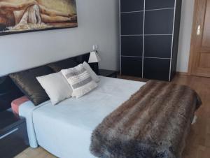 Precioso piso con ducha hidromasaje VUT-LE-726 في أستورغا: غرفة نوم مع سرير أبيض مع بطانية فراء مزيفة