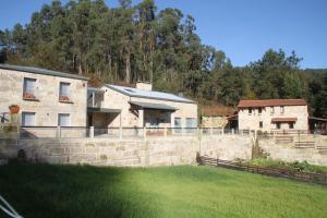 una casa con una pared de piedra junto a un patio en Hotel a Ecogranxa en Pontevedra