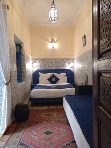 a bedroom with a bed with a blue head board at Riad El Filali in Marrakech