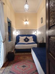 - une chambre avec un lit à tête bleue dans l'établissement Riad El Filali, à Marrakech