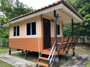 a tiny house with a chair in front of it at Nantawanhomestay in Lampang