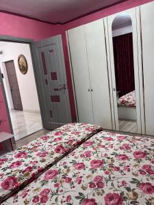 a bedroom with a bed with a floral bedspread at Apartament In Centrul Orasului in Bacău