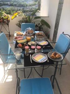 - une table avec de la nourriture et des chaises bleues dans l'établissement Casa Simba B&B Adults Only, à Estepona