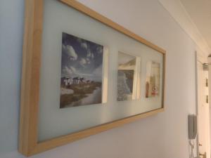 a picture frame on a wall with two pictures on it at Station View in Oban