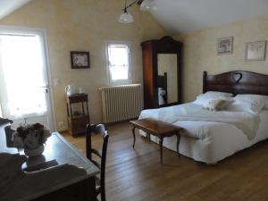 Un dormitorio con una cama y una mesa. en Le Clos des Bérengeries, en Saint-Patrice