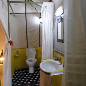 uma pequena casa de banho com WC e lavatório em djou luxury desert camp em Merzouga