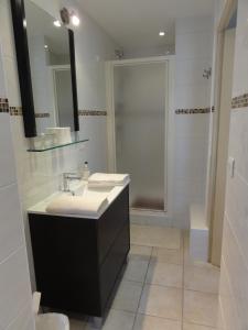 y baño blanco con lavabo y ducha. en Le Clos des Bérengeries, en Saint-Patrice