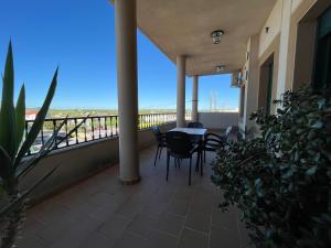 balcón con mesa y sillas y vistas a la playa en Hostal Parador de los Llanos en Torreorgaz
