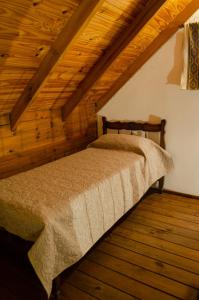 una camera con letto in una stanza con soffitti in legno di Espacio Infinito a Capilla del Monte
