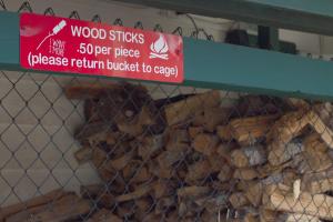 una cerca con un cartel con palos de madera en Arrow Creek Camp and Cabins, en Gatlinburg