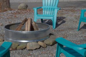 een vuurplaats met twee stoelen en een tafel en stoelen bij Arrow Creek Camp and Cabins in Gatlinburg