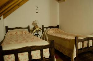 a bedroom with two beds and a lamp at Espacio Infinito in Capilla del Monte