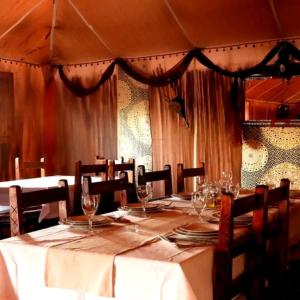 uma mesa com copos de vinho num restaurante em djou luxury desert camp em Merzouga