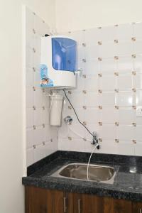 a bathroom with a sink and a tv on the wall at DivBnK homes Bangalore in Bangalore