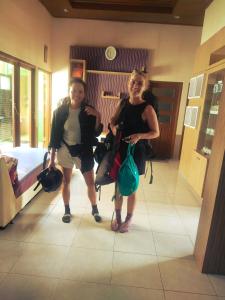 two women are standing in a room with their hair at Mocca Guest House in Banyuwangi