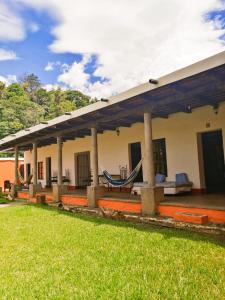 una casa con una hamaca delante en Hostel Hopa Antigua, en Antigua Guatemala
