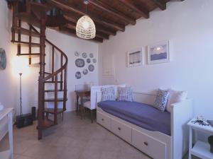 a bedroom with a bed and a spiral staircase at In Alto holiday home in Plaka Milos in Plaka Milou