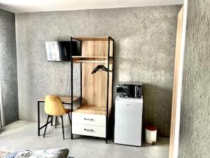eMbalenhleにあるEmba Guest lodge No loadsheddingのデスク、椅子、冷蔵庫が備わる客室です。