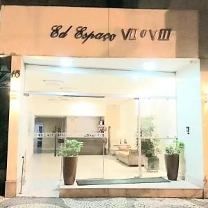 a store front with two potted plants in the window at Flat Praia de Icaraí, 2 qts, 1vaga garagem e piscina in Niterói