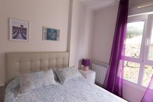1 dormitorio con 1 cama con cortinas moradas y ventana en Telmo's Home con PARKING, en Zumaia