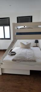 Cama blanca en habitación blanca con marco de cama en Turmklause en Luckenwalde