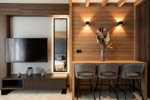 a living room with a table and chairs and a television at Woodside Residences & SPA in Kopaonik