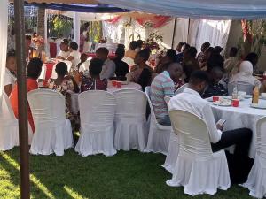 eine Gruppe von Personen, die an Tischen unter einem Zelt sitzen in der Unterkunft Africa Lodge Arusha in Nkoaranga