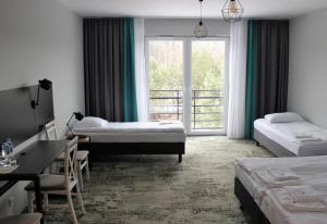 a hotel room with two beds and a window at Albizja Hotel in Szczytno