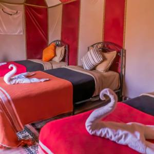 um quarto com duas camas com cisnes em djou luxury desert camp em Merzouga