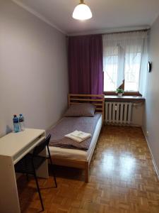 1 dormitorio con cama, mesa y ventana en Mieszkanie na Mickiewicza 7 en Olkusz