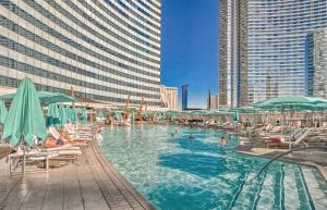 una piscina con sillas y sombrillas en una ciudad en Vdara Studio Suite 011 Pool View FREE VALET Parking, en Las Vegas