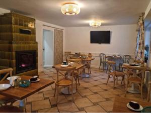 a dining room with tables and a fireplace at Villa Marbela in Ustka