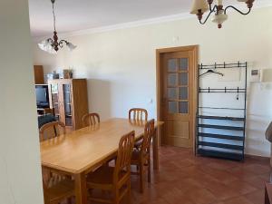 a kitchen and dining room with a wooden table and chairs at t2 armação de pêra in Armação de Pêra