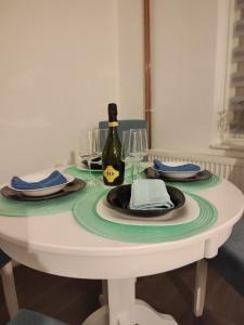 帕莱Janković apartman的一张带一瓶葡萄酒和眼镜的白色桌子 更多1张照片