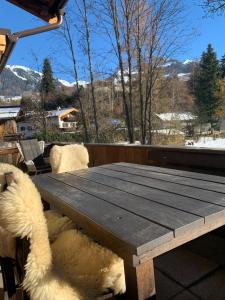 un tavolo di legno con un cane seduto attorno di Ferienwohnung Kiem a Kitzbühel